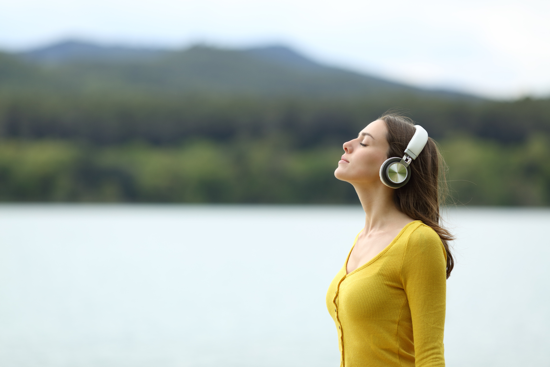 Woman meditating listening audio guide outdoors